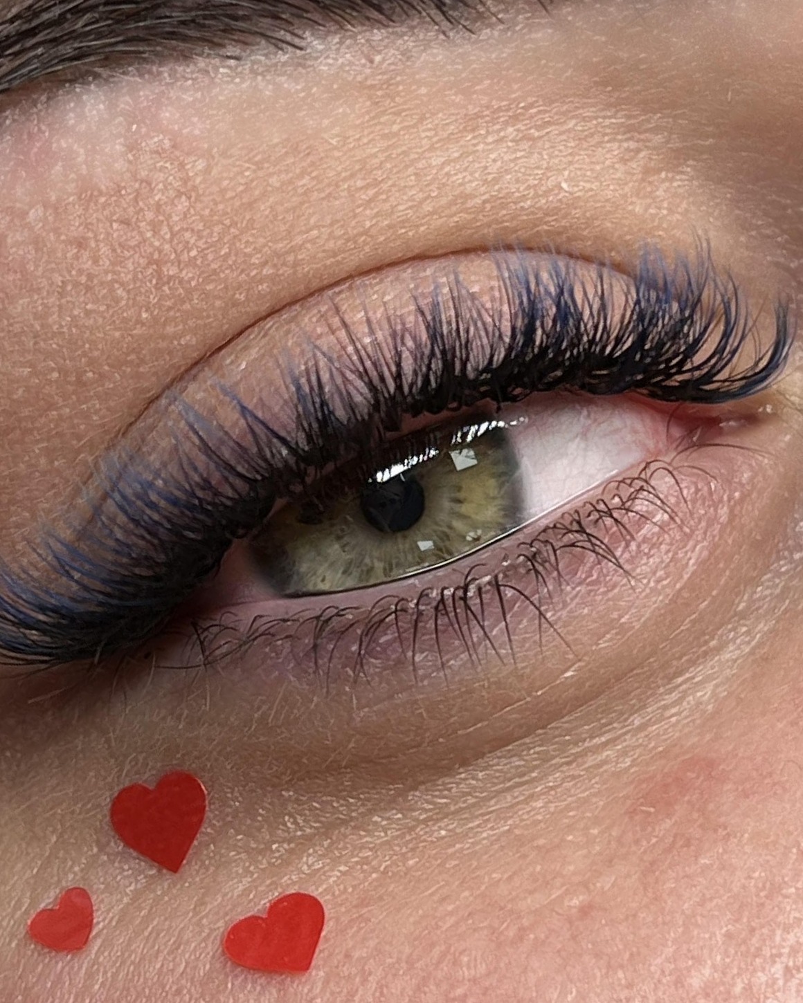 Russian volume wimperextensions met blauwe ombre, met rode hartjes op de wang